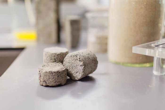 Three small cylinder-shaped bricks on a lab table.