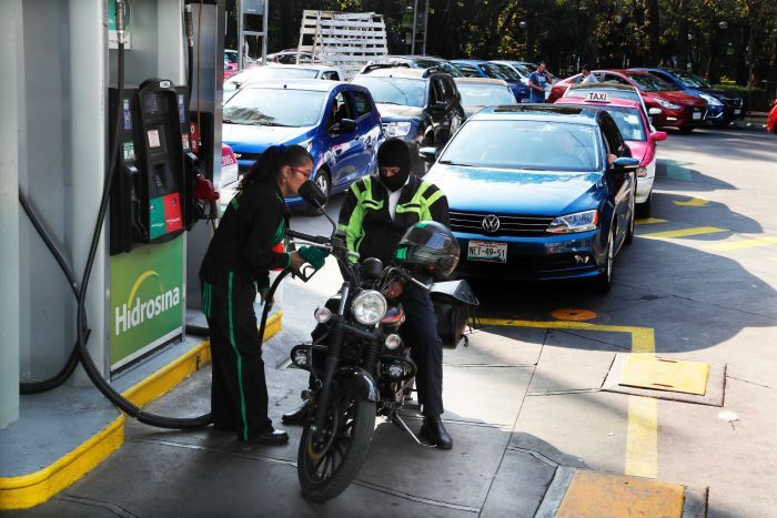 Vehicles stand in line to fill up their fuel tanks at a gas station in Mexico.